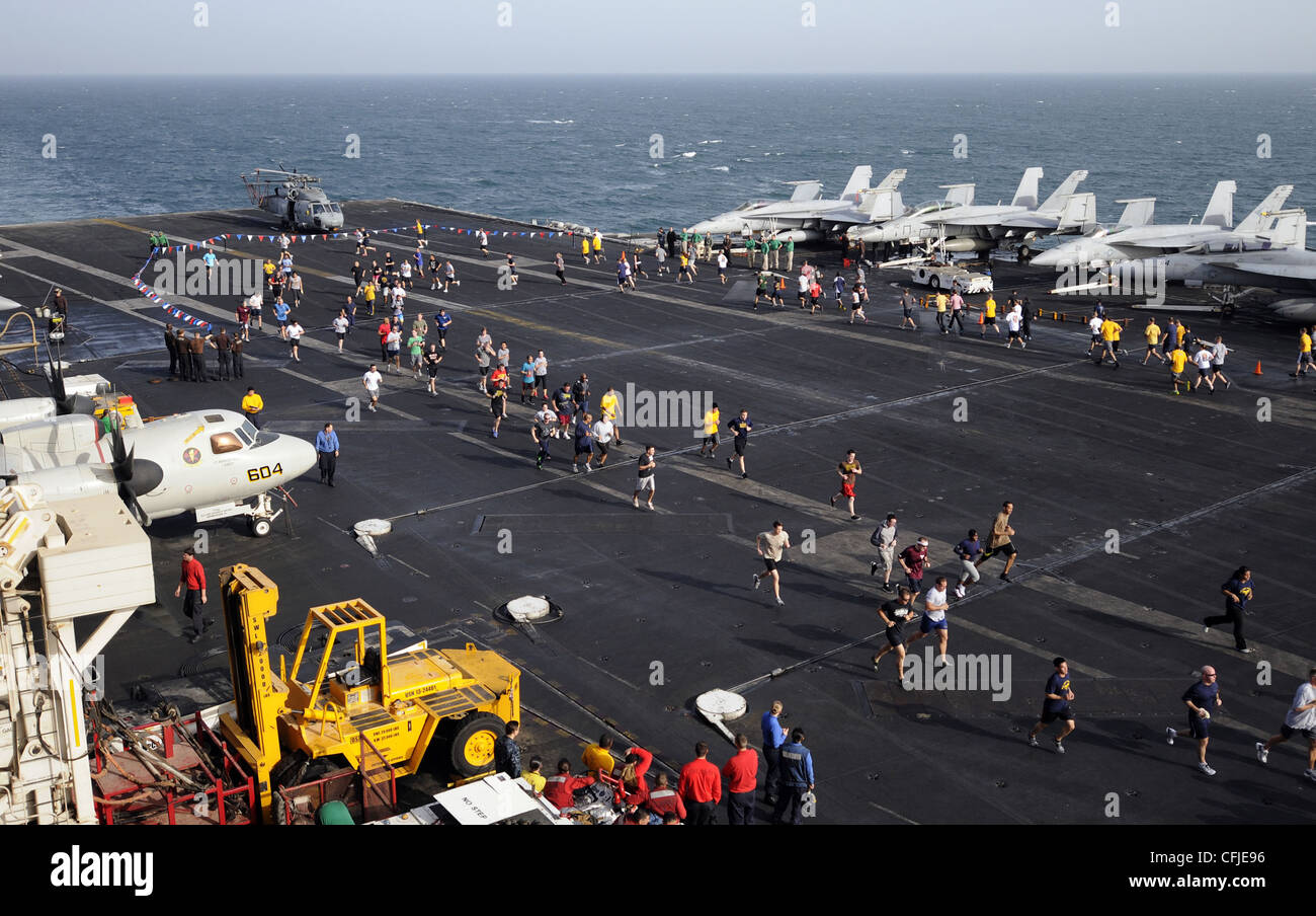 I marinai partecipano a una corsa di divertimento 5K ospitata dalla divisione morale, Welfare e Recreation della nave sul ponte di volo della compagnia aerea di classe Nimitz USS Carl Vinson (CVN 70). Carl Vinson e Carrier Air Wing (CVW) 17 sono distribuiti nell'area di responsabilità della 5a flotta statunitense. Foto Stock