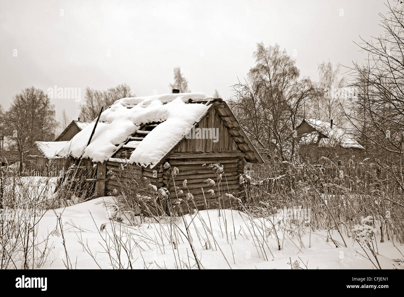 Vecchia casa in legno tra la neve Foto Stock