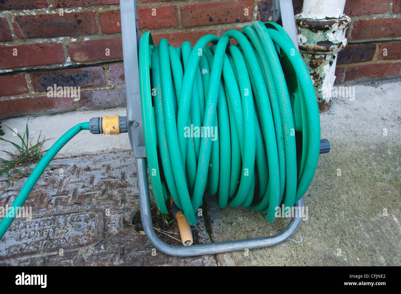 Tubo flessibile su una bobina in giardino dormienti di posa con il tubo flessibile divieto in molte zone del paese Foto Stock