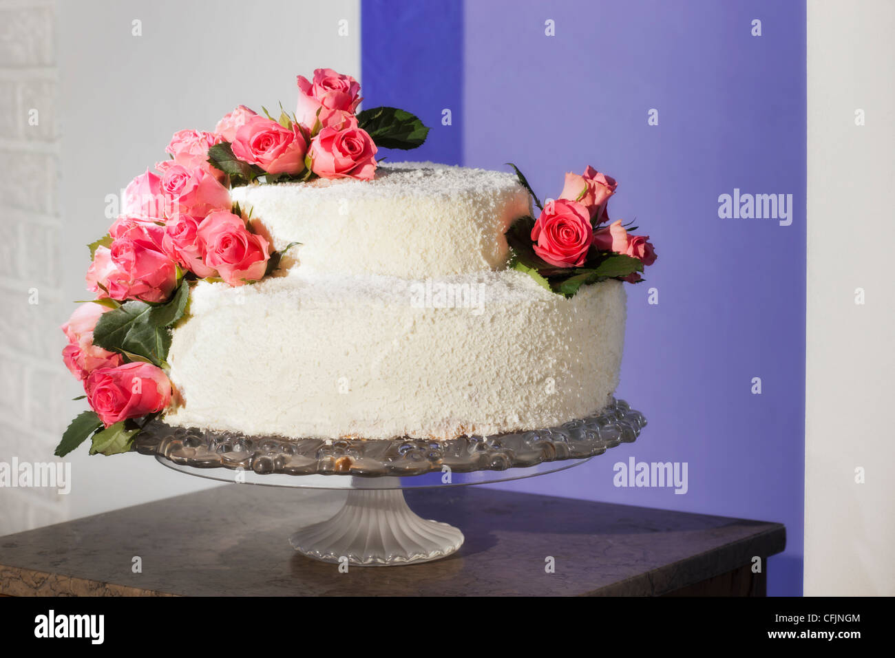Torta nuziale decorata con veri fiori di rosa Foto Stock