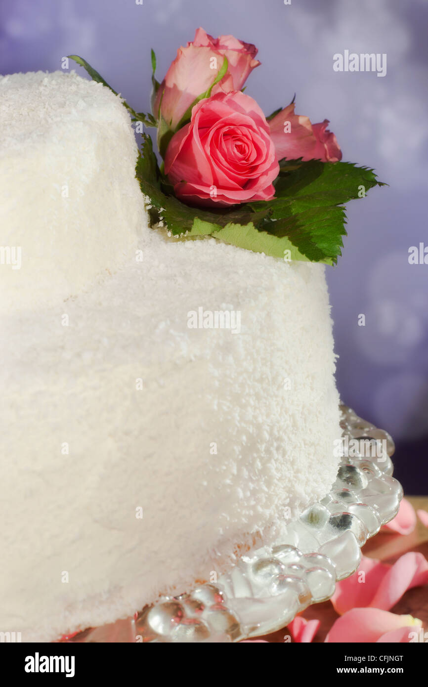 Torta nuziale decorata con veri fiori di rosa Foto Stock