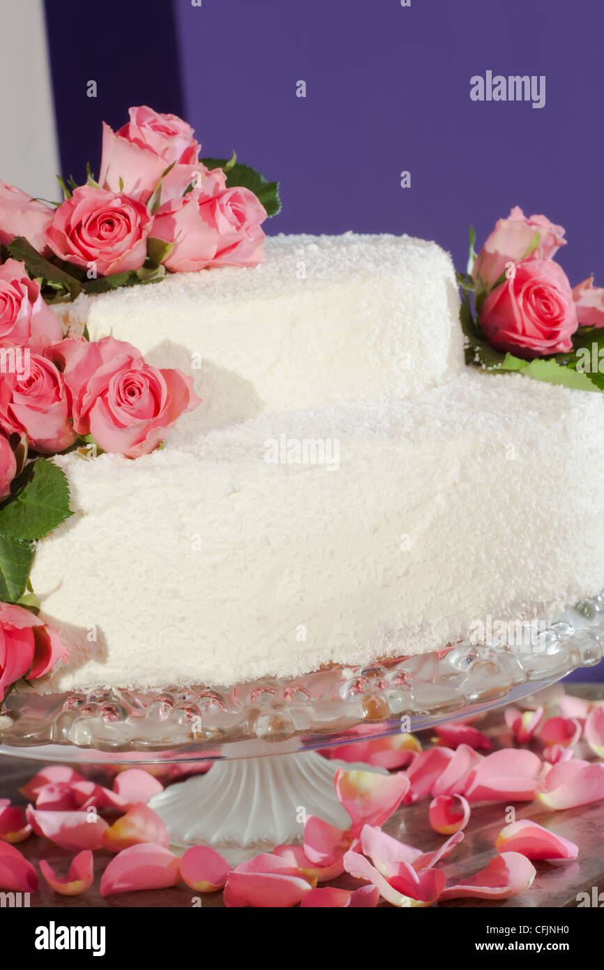 Torta nuziale decorata con veri fiori di rosa Foto Stock