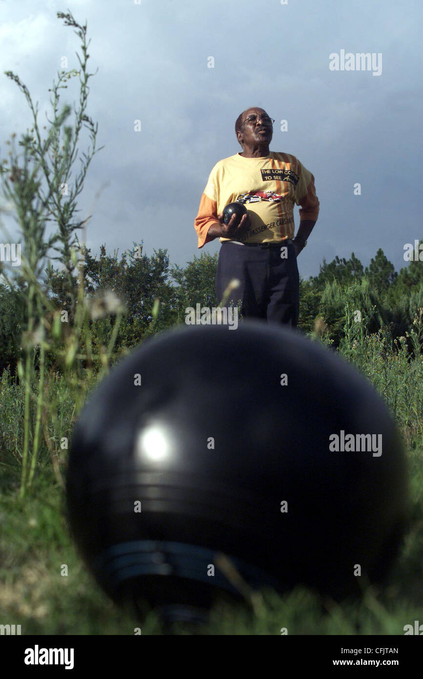 Elliot Mashego del Dube Bowling Club di Soweto sorge nel pesco che ha a lungo erba non tagliata a causa di un guasto di local coun Foto Stock