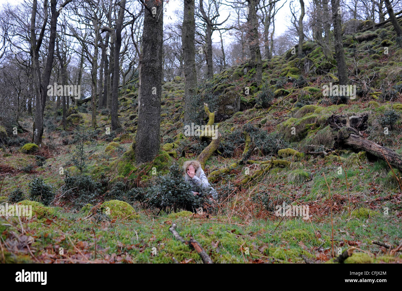 Donna di mezza età catturati a breve spendere un centesimo all'aperto mentre si cammina nel Lake District Cumbria Regno Unito Foto Stock