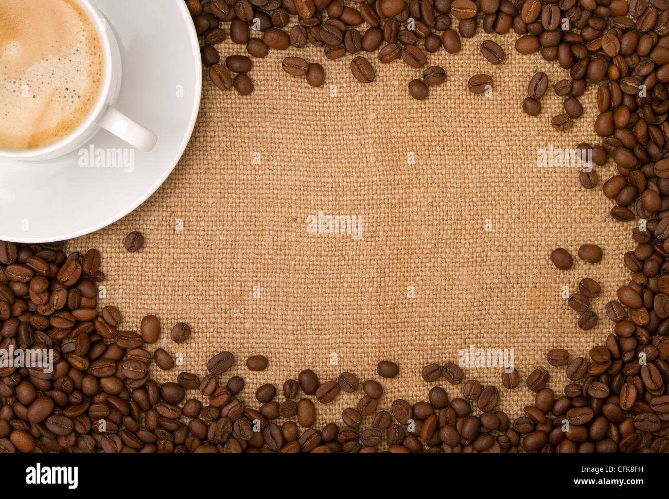 Tela canvas, come sfondo, i chicchi di caffè come un telaio, e una tazza di caffè Foto Stock