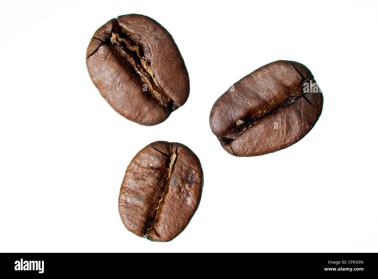 Tre arabica coffee beans su sfondo bianco. Foto Stock