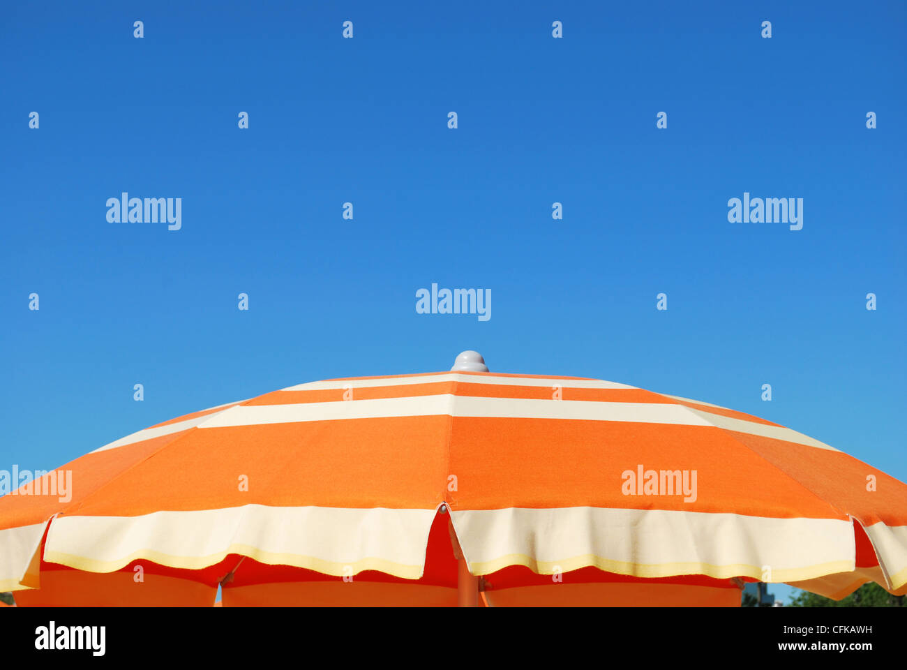 Arancio listati ombrellone oltre il cielo blu, libera lo spazio per testo, Rimini, Italia Foto Stock