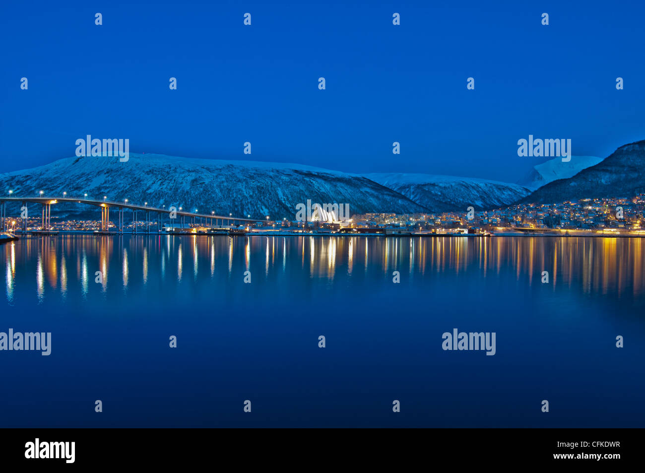 Vista da Tromso in Norvegia attraverso il mare di Norvegia guardando verso Tromso Eismeerkathedrale al centro dell'immagine. Foto Stock
