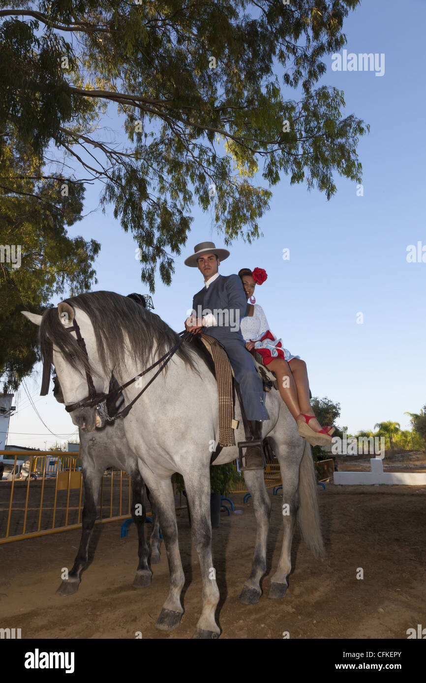 Lo spagnolo horseman con la donna riding pillion sul grigio di un cavallo andaluso. Foto Stock