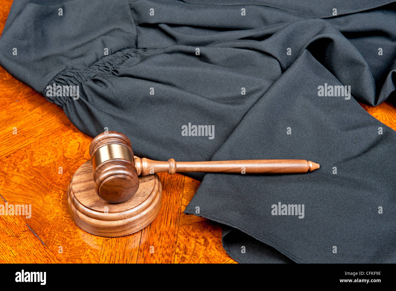 Un giudice di camice e martello con blocco audio su un profondo e ricco di legno colorato desktop Foto Stock