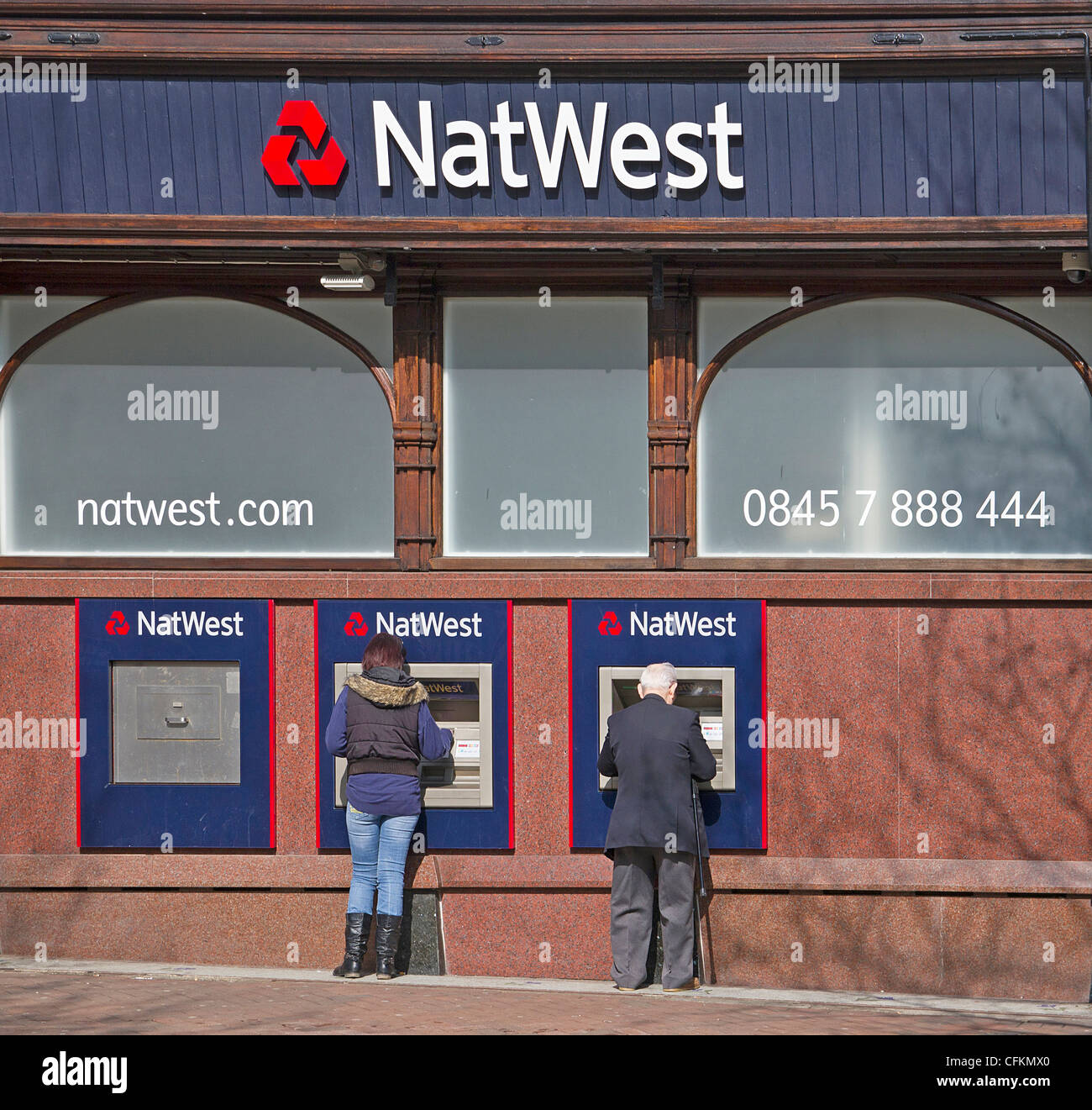 Le persone che usano le macchine ATM a NatWest Bank High Street Ashford Kent REGNO UNITO Foto Stock