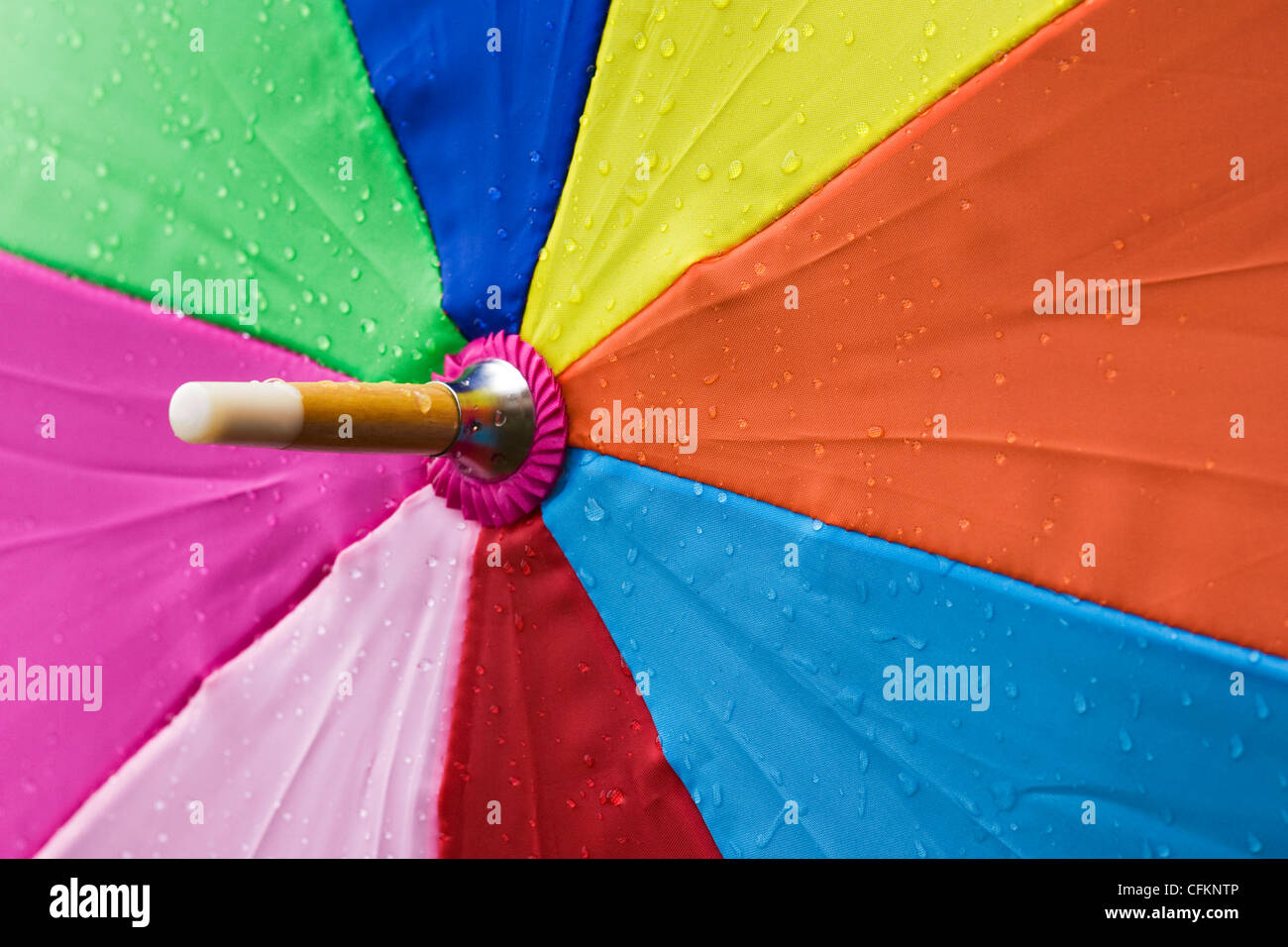 Close up di un ombrello multicolore sotto la pioggia. Foto Stock