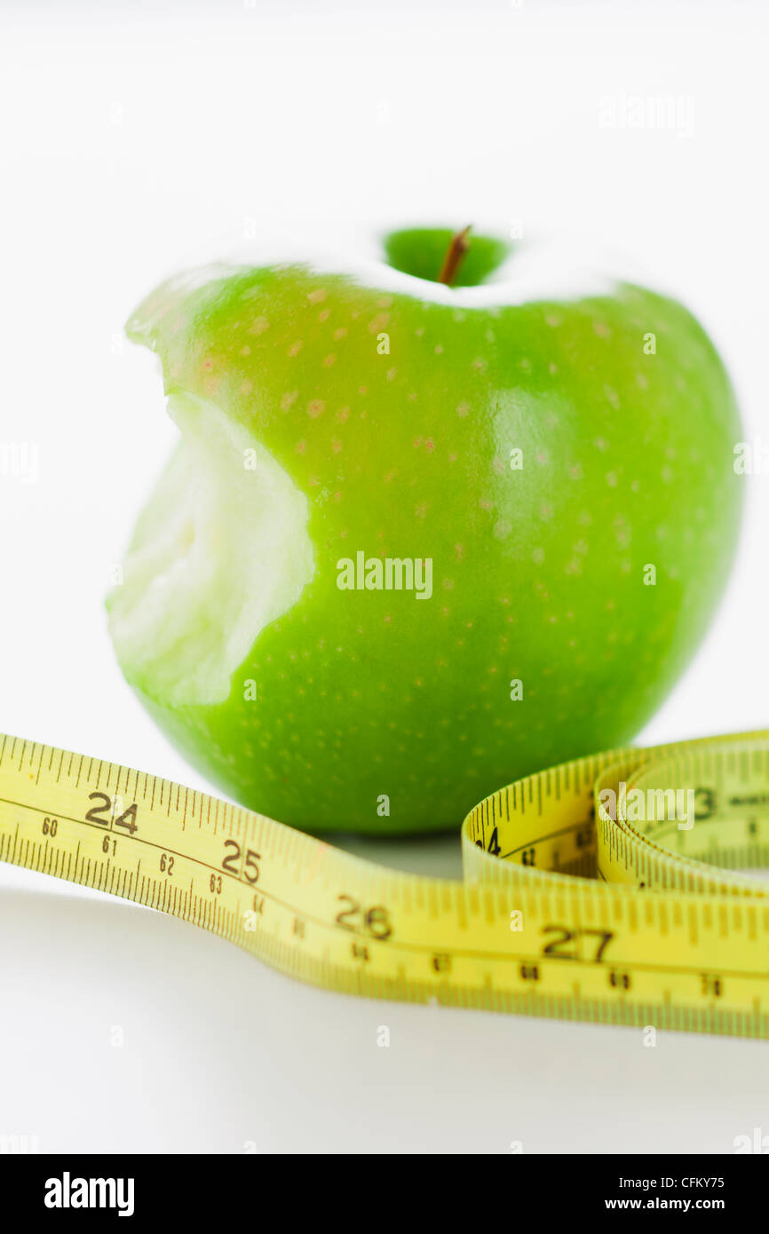 Verde mela con nastro di misurazione Foto Stock