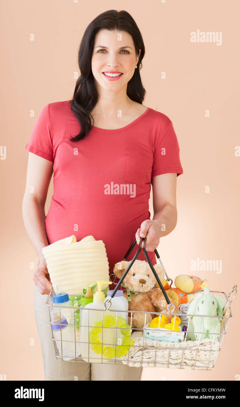 Studio ritratto di donna con carrello pieno di merci bambino Foto Stock Studio ritratto di donna con carrello pieno di merci bambino Foto Stock