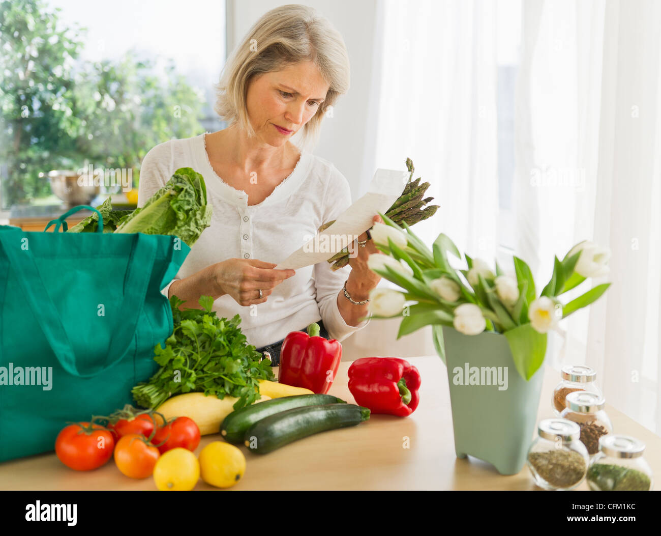 Stati Uniti d'America, New Jersey, Jersey City, ritratto di donna senior con shopping bag in cucina Foto Stock