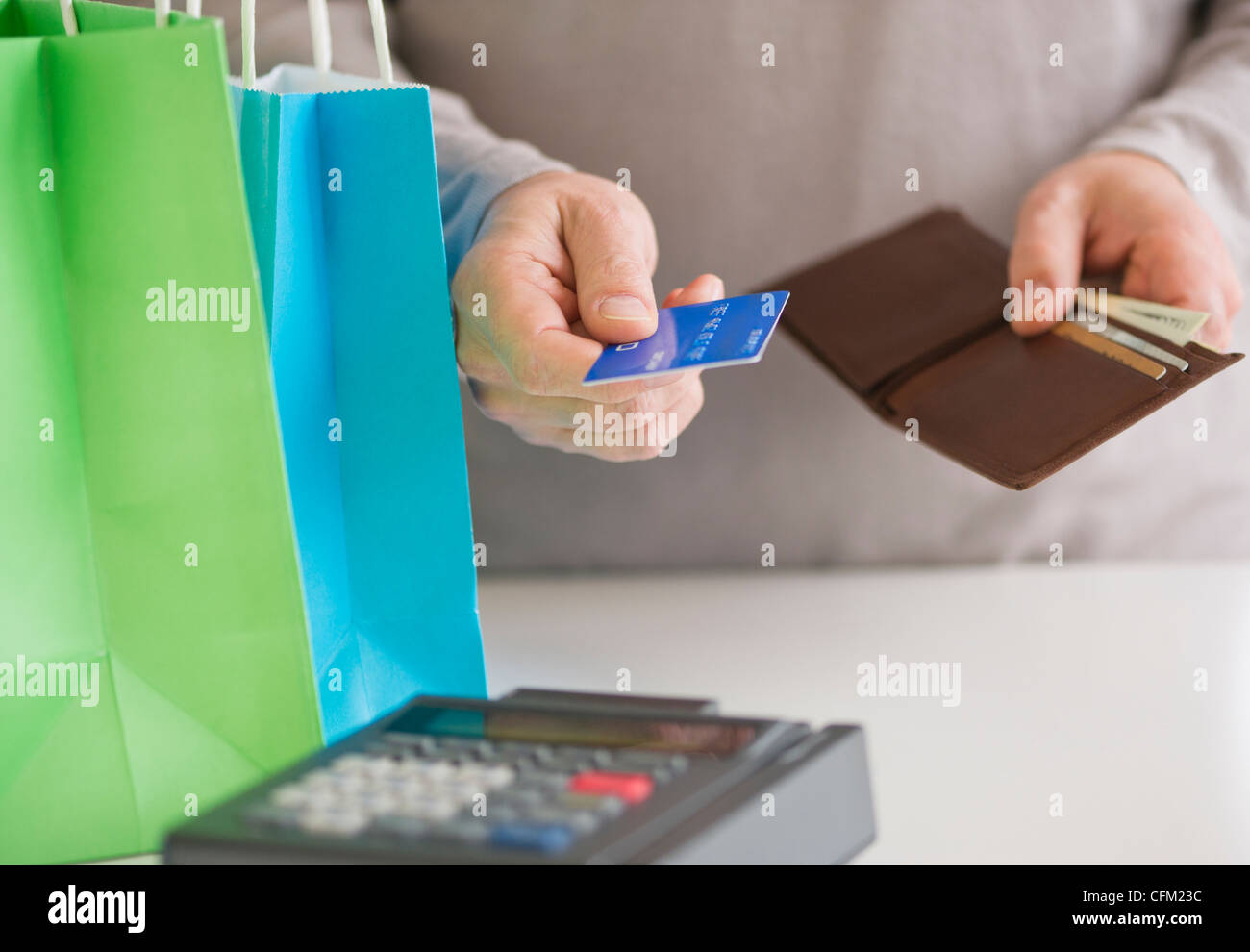 Close up di uomo di mani tenendo la carta di credito e il portafoglio, studio shot Foto Stock Close up di uomo di mani tenendo la carta di credito e il portafoglio, studio shot Foto Stock