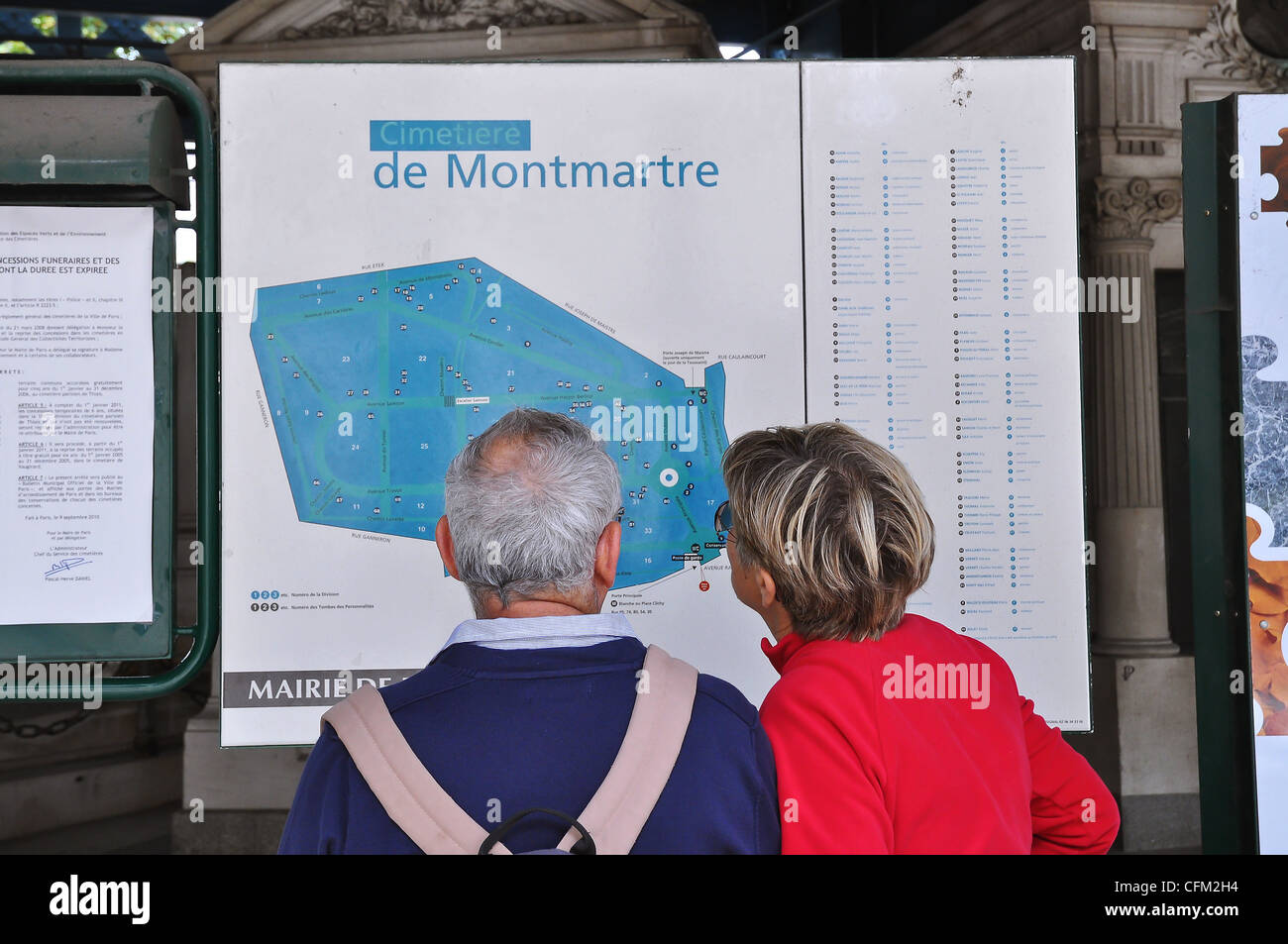 Due persone che studiano la mappa al cimitero di Montmartre, Parigi. casa di molti francesi ed europei e culturali del passato grandi. Foto Stock