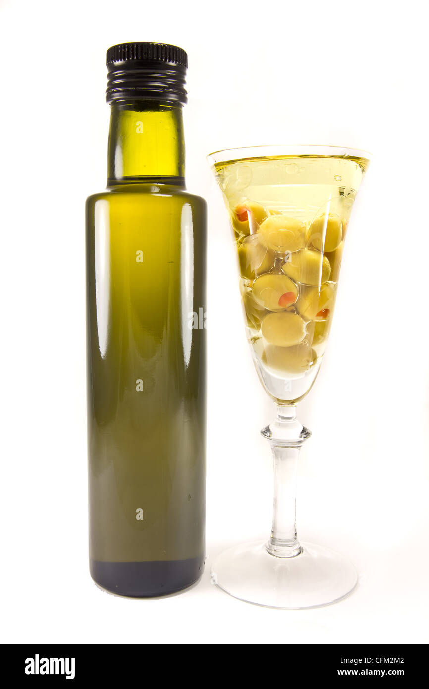 Immagine di una bottiglia di olio di oliva e le olive in un bicchiere da vino Foto Stock
