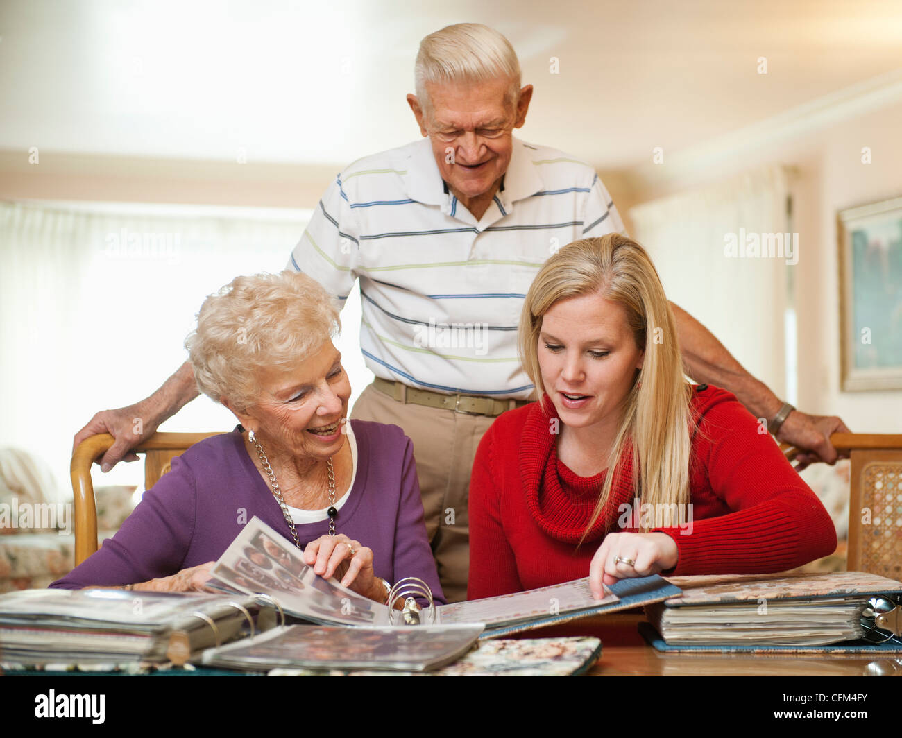 Stati Uniti d'America, Utah, Salt Lake City, coppia Senior e metà donna adulta guarda la famiglia album di ritagli Foto Stock