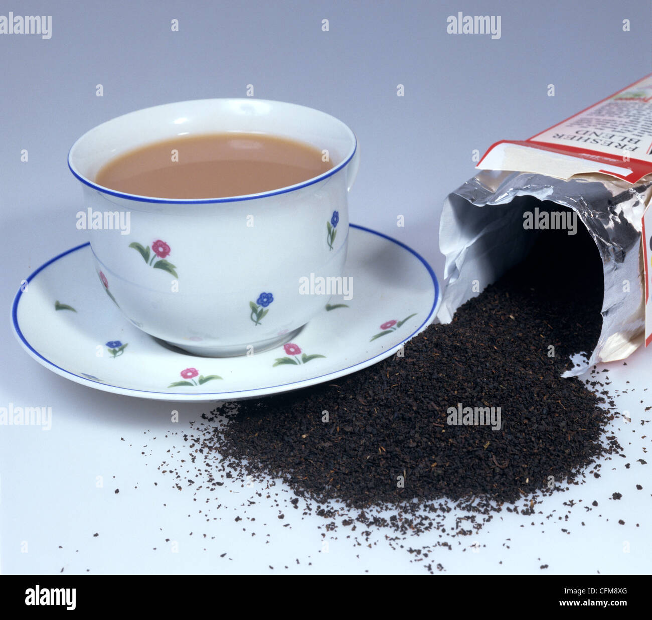 Tazza di tè nero con latte e tè pacchetto e le foglie di tè Foto Stock