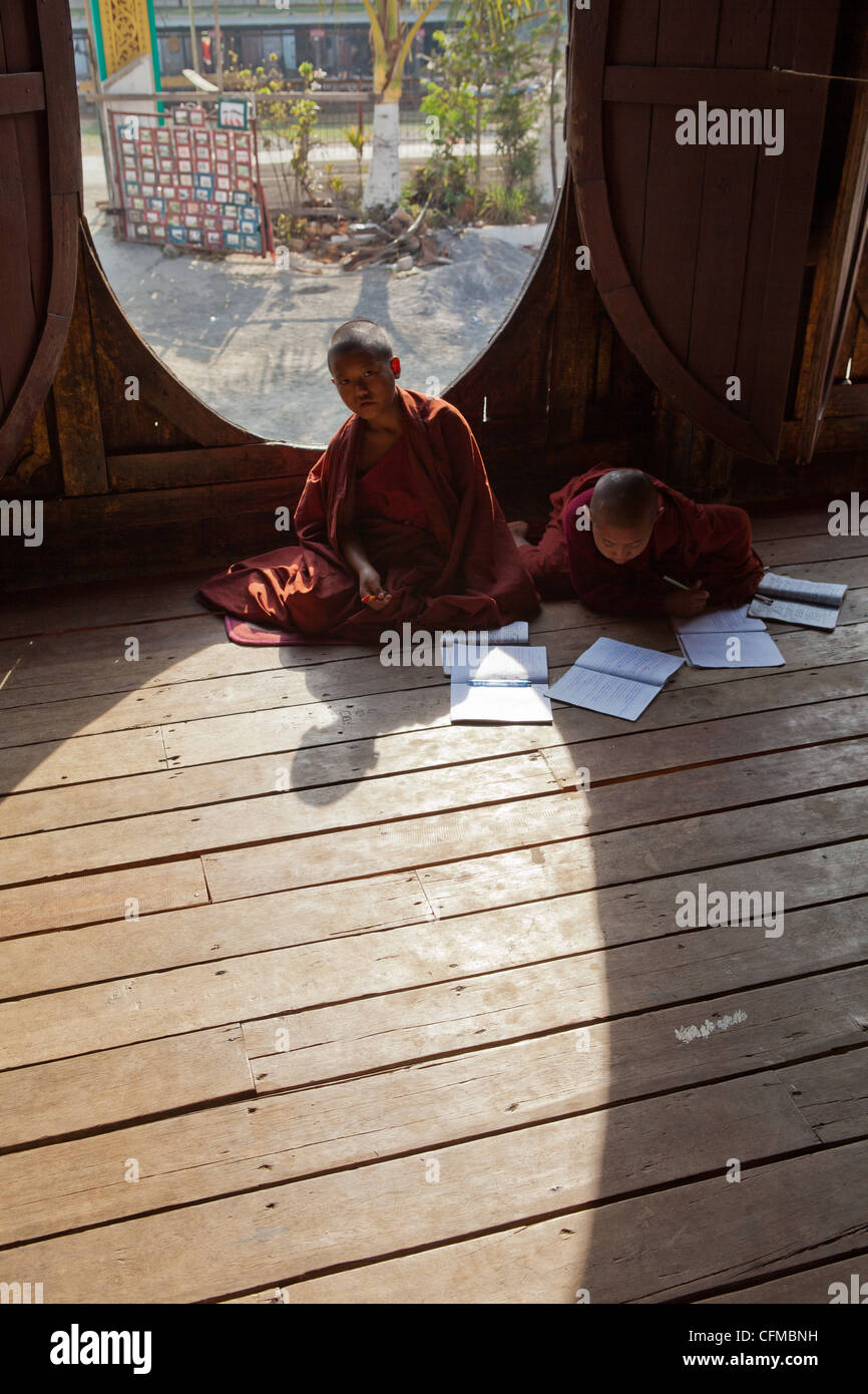 L'unico finestre ovali a questo antico monastero in teak in Shwenyaung, vicino al Lago Inle,serve come una scuola per giovani monaci novizio. Foto Stock