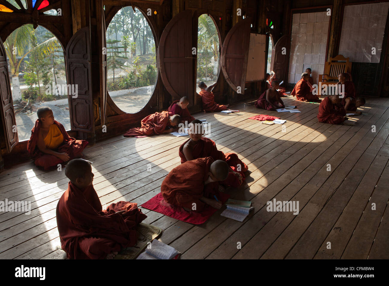 L'unico finestre ovali a questo antico monastero in teak in Shwenyaung, vicino al Lago Inle,serve come una scuola per giovani monaci novizio. Foto Stock
