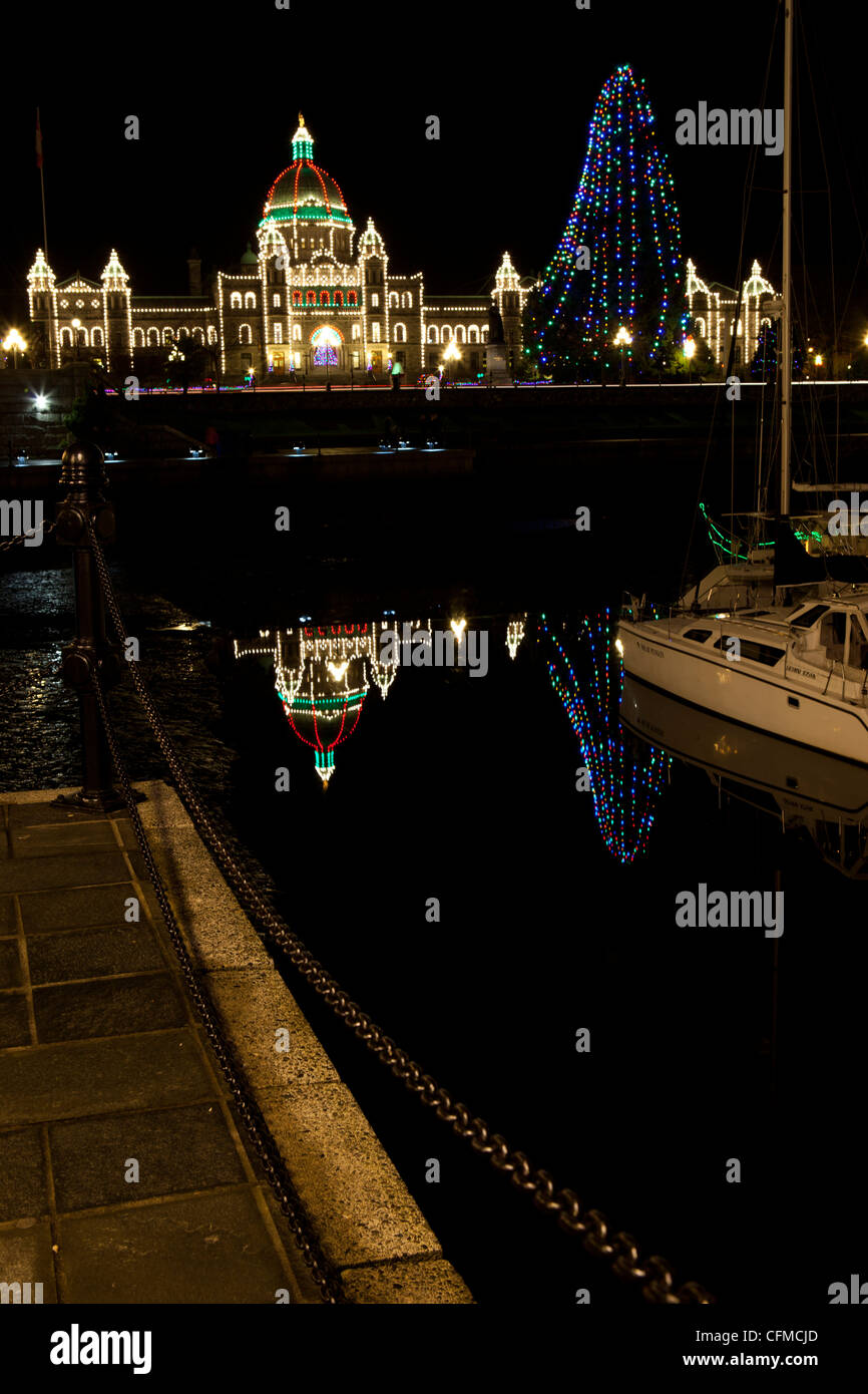 Victoria's agli edifici del parlamento a Natale riflettendo nel porto interno. Foto Stock