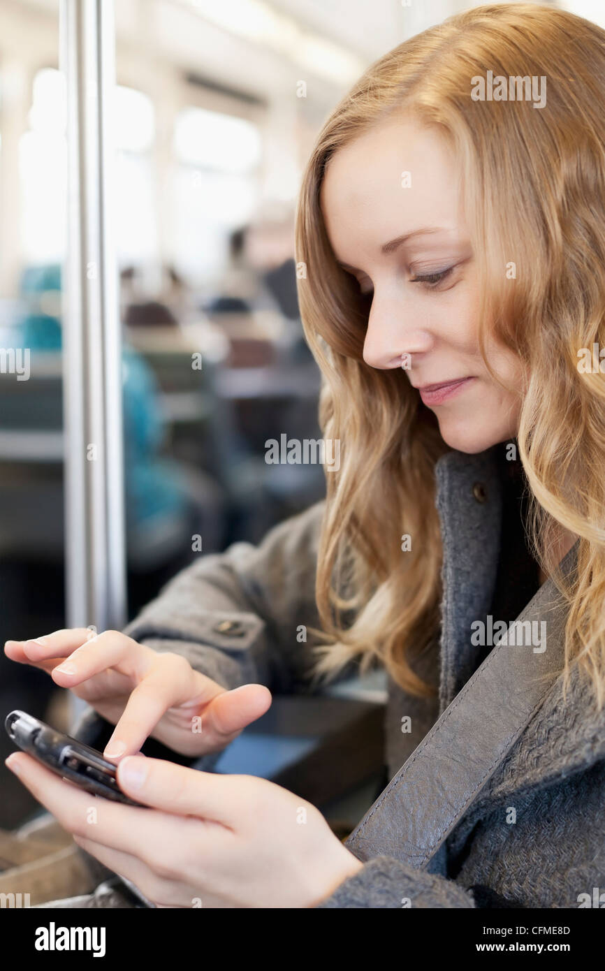 Stati Uniti, California, Los Angeles, donna l'invio di messaggi di testo in treno della metropolitana Foto Stock