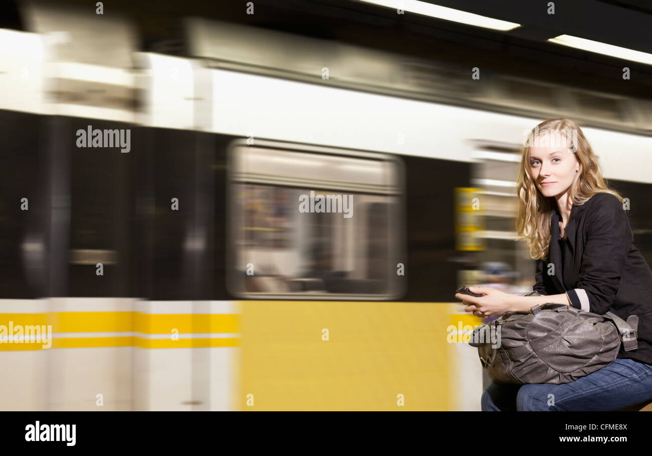 Stati Uniti, California, Los Angeles, donna l'invio dei messaggi di testo sulla stazione della metropolitana Foto Stock
