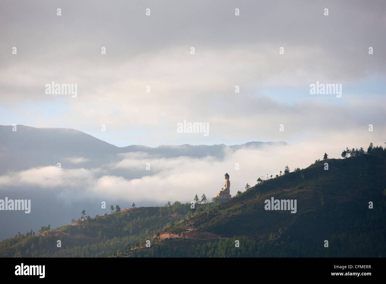 Misty la mattina presto vista del gigante Buddha d'oro essendo costruito su una collina boschiva fuori Thimpu, Bhutan, Asia Foto Stock