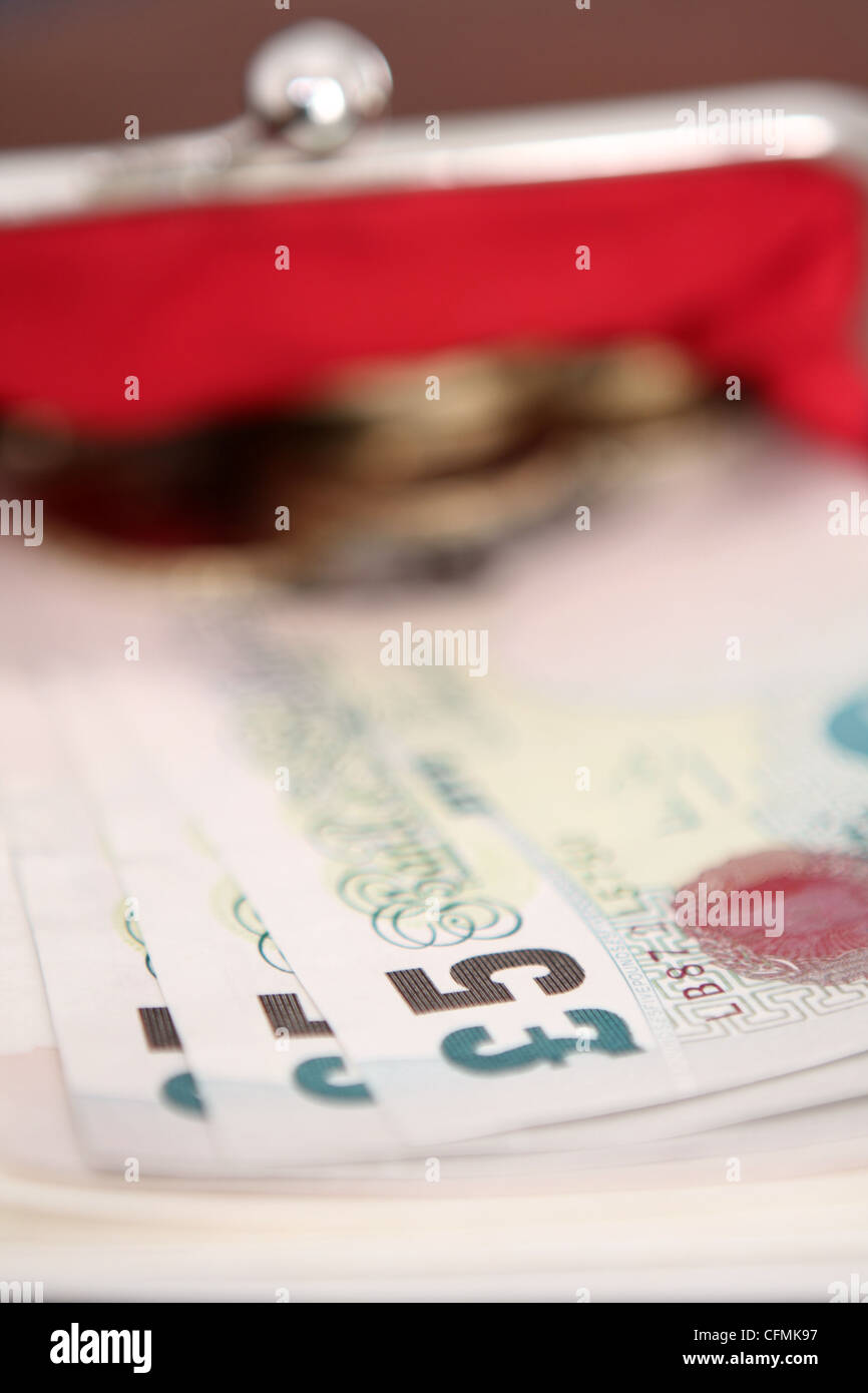 Sterling le banconote e le monete metalliche sporgenti di una signora della borsa Foto Stock