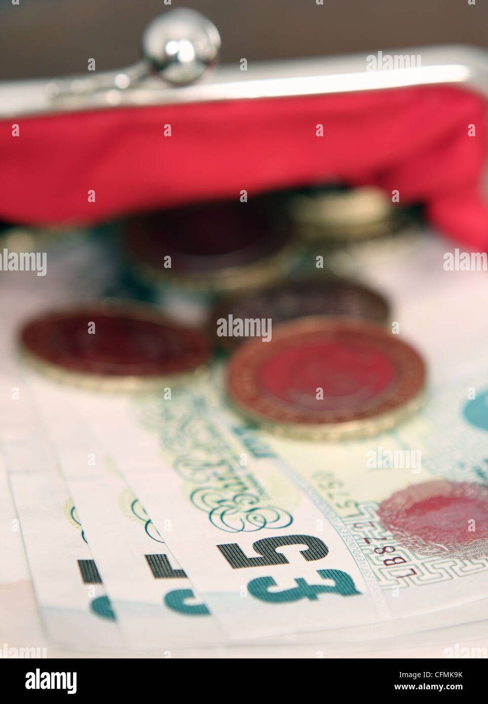 Sterling le banconote e le monete metalliche sporgenti di una signora della borsa Foto Stock