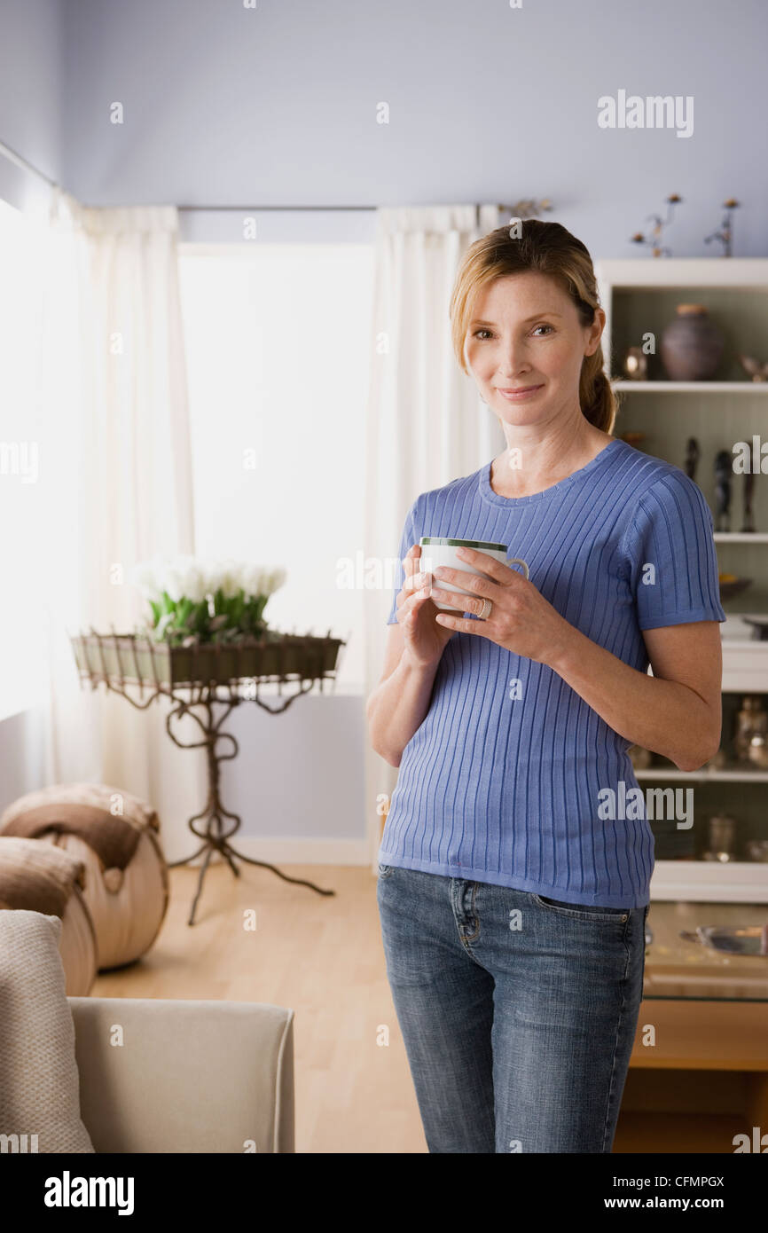 Stati Uniti, California, Los Angeles, Donna in soggiorno azienda mug Foto Stock