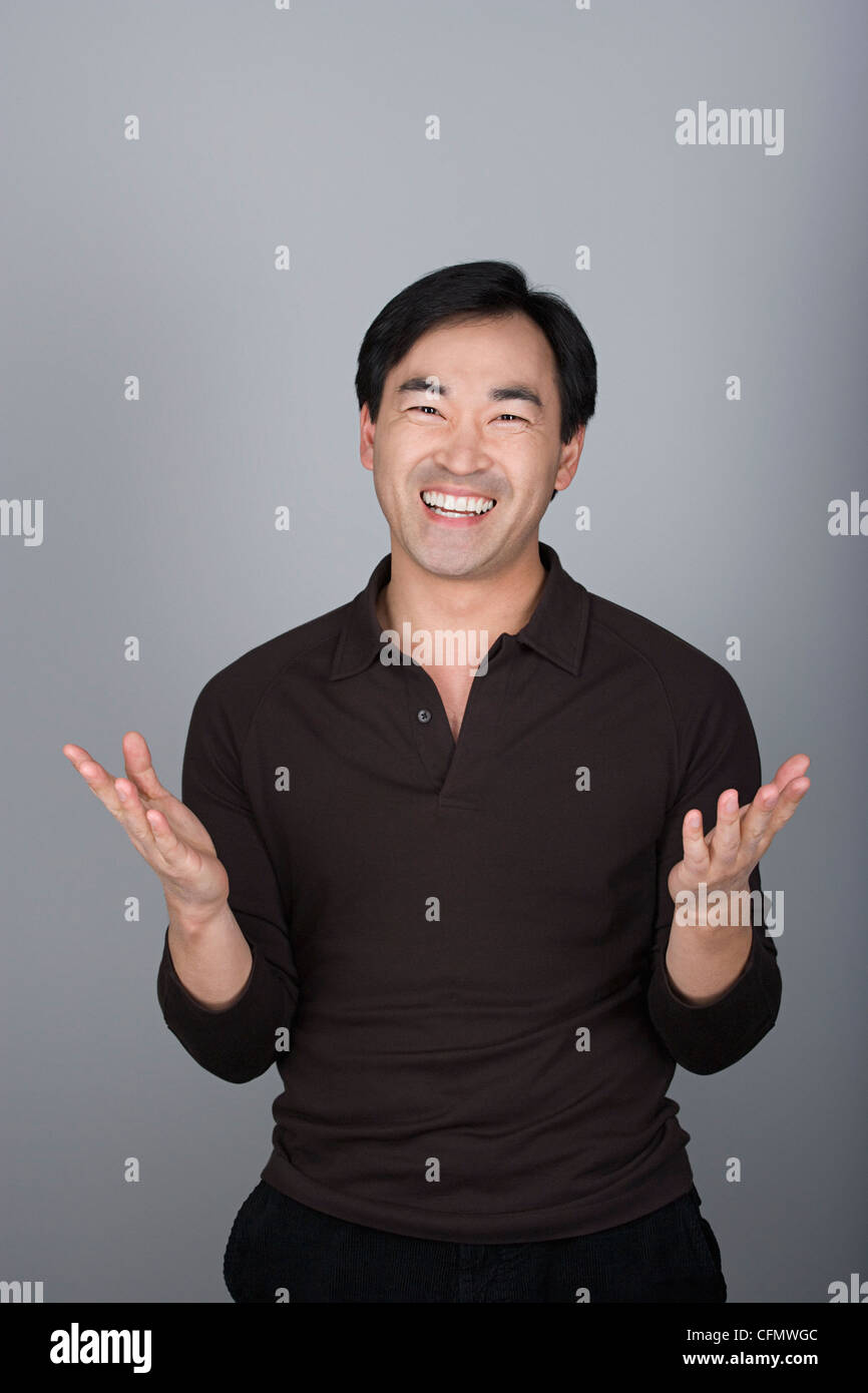 Studio shot ritratto di uomo maturo con le mani alzate, vita fino Foto Stock