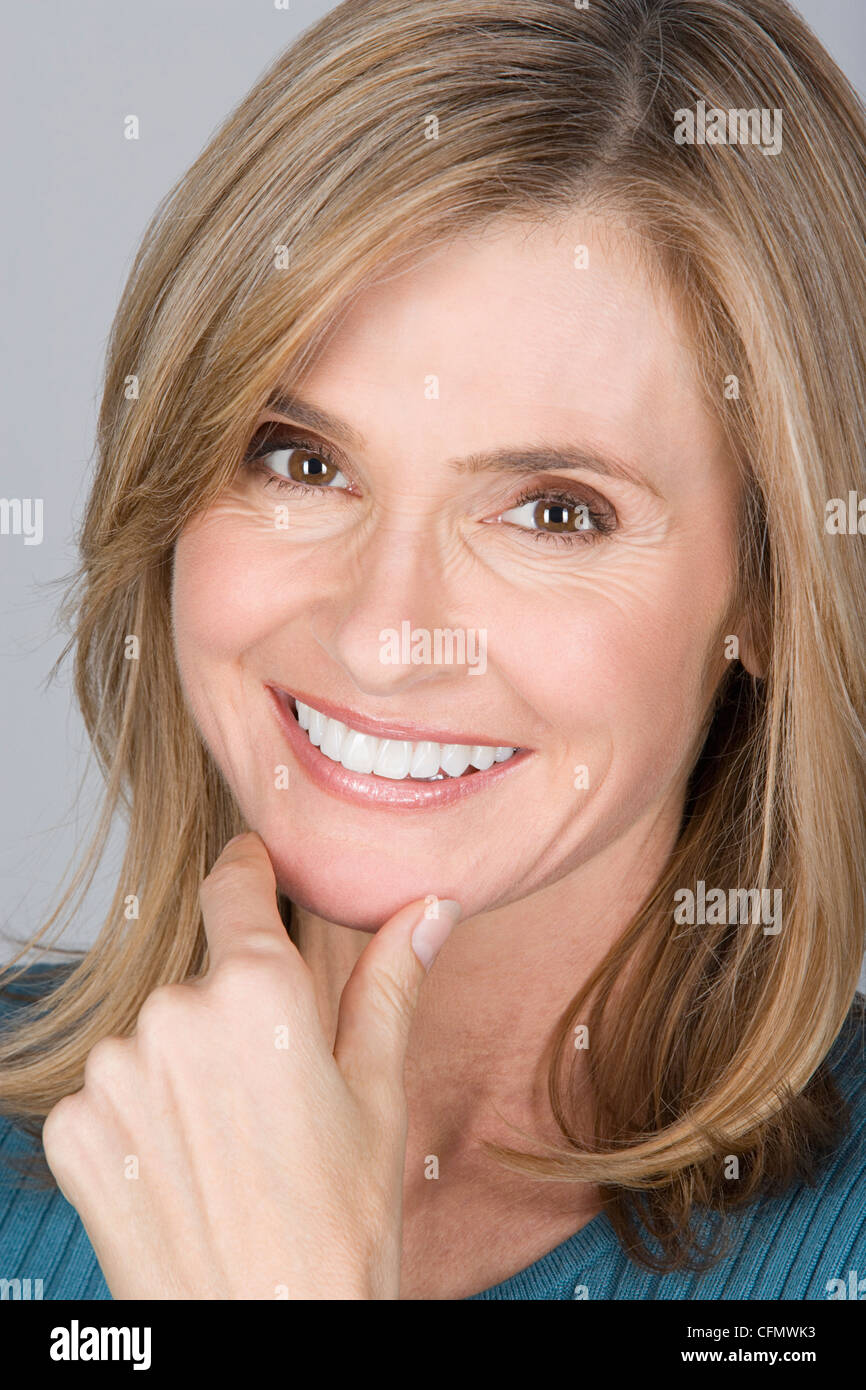 Studio shot ritratto di donna matura con mano sul mento, close-up Foto Stock