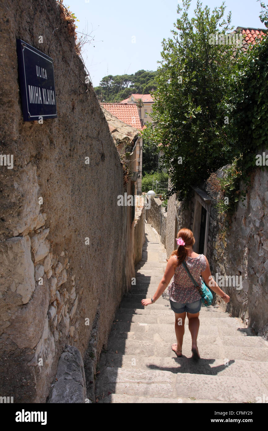 Passeggiate turistiche giù per la strada stretta. Dubrovnik, Croazia Foto Stock