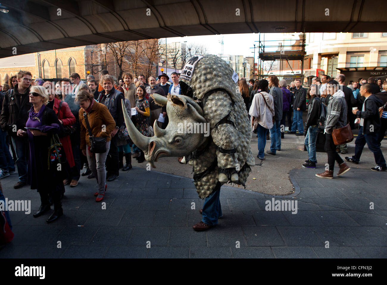 Uomo vestito in un costume di rhino fuori la Hammersmith Apollo con il pubblico in attesa di Douglas Adams salva la notte di Rhino Foto Stock