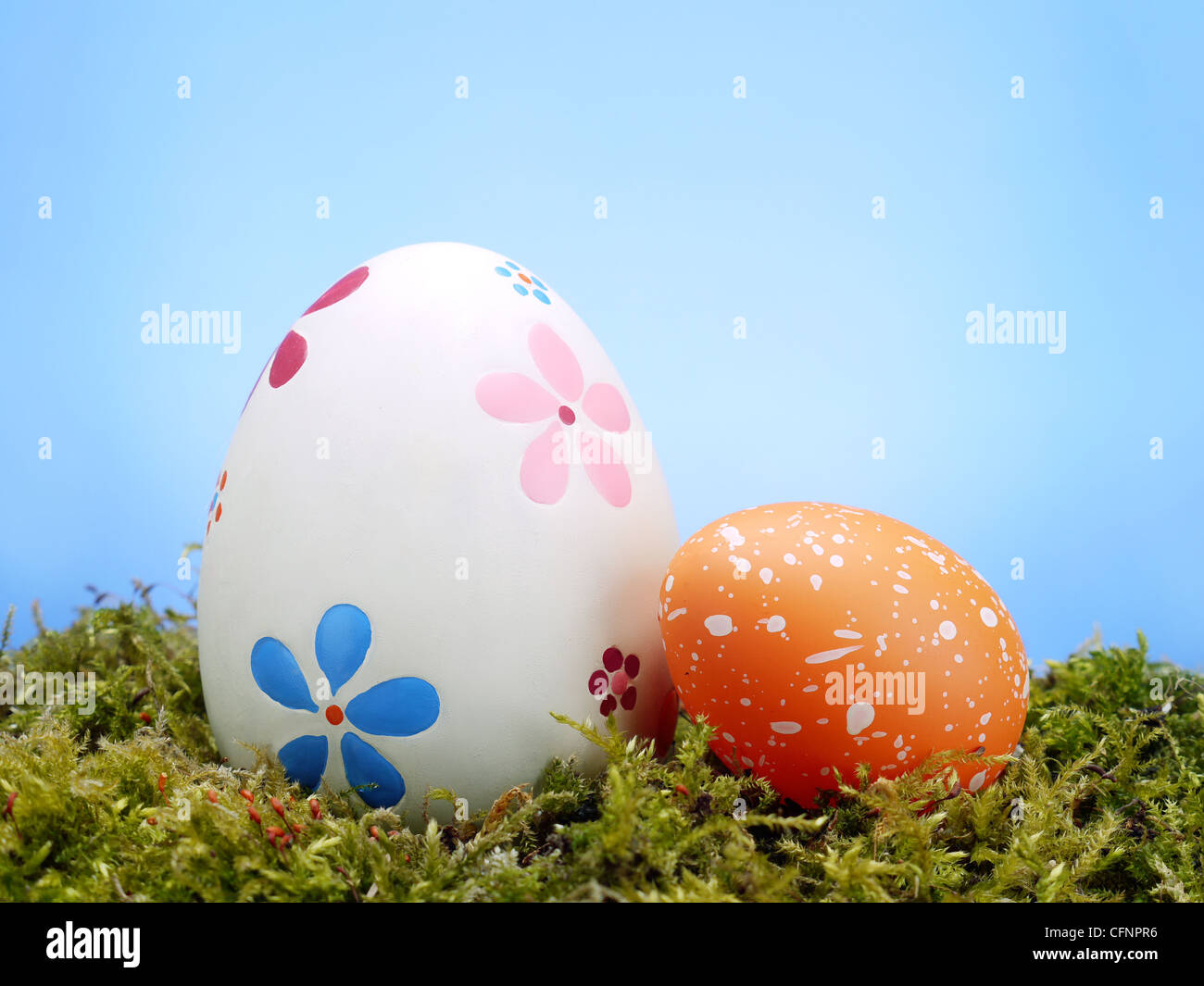 Due uova di Pasqua in erba oltre il cielo blu Foto Stock