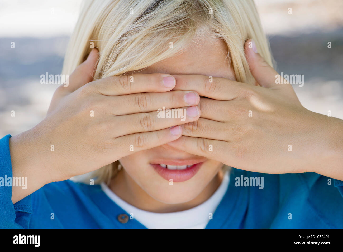 Ragazzo che copre gli occhi con le mani Foto Stock