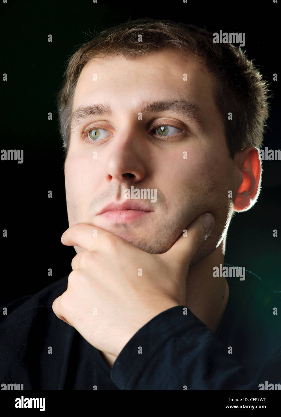 Uomo di pensiero in un studio. Sfondo nero Foto Stock