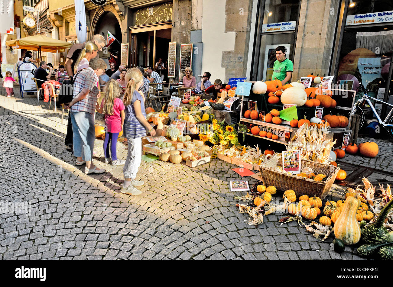 La famiglia di fronte a una bancarella vendendo le zucche frutta e verdura presso il mercato settimanale in Tuebingen, Wochenmarkt a Tübingen, Foto Stock