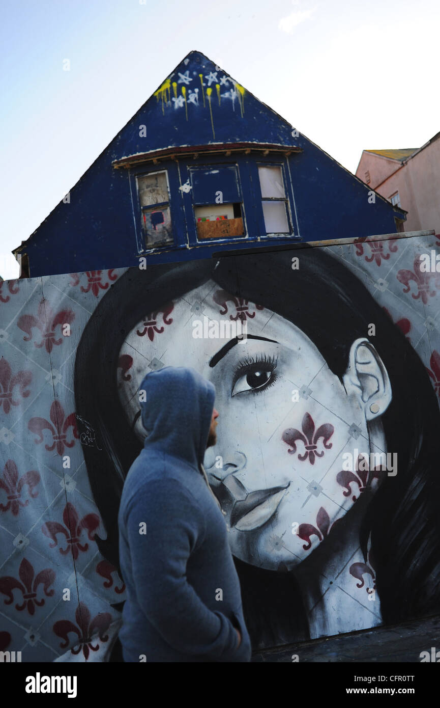 Stati Uniti d'America Sud della California a Los Angeles Venice Beach L.A. CA uomo camminare davanti a un murale di una donna di fronte a un intavolato house Foto Stock