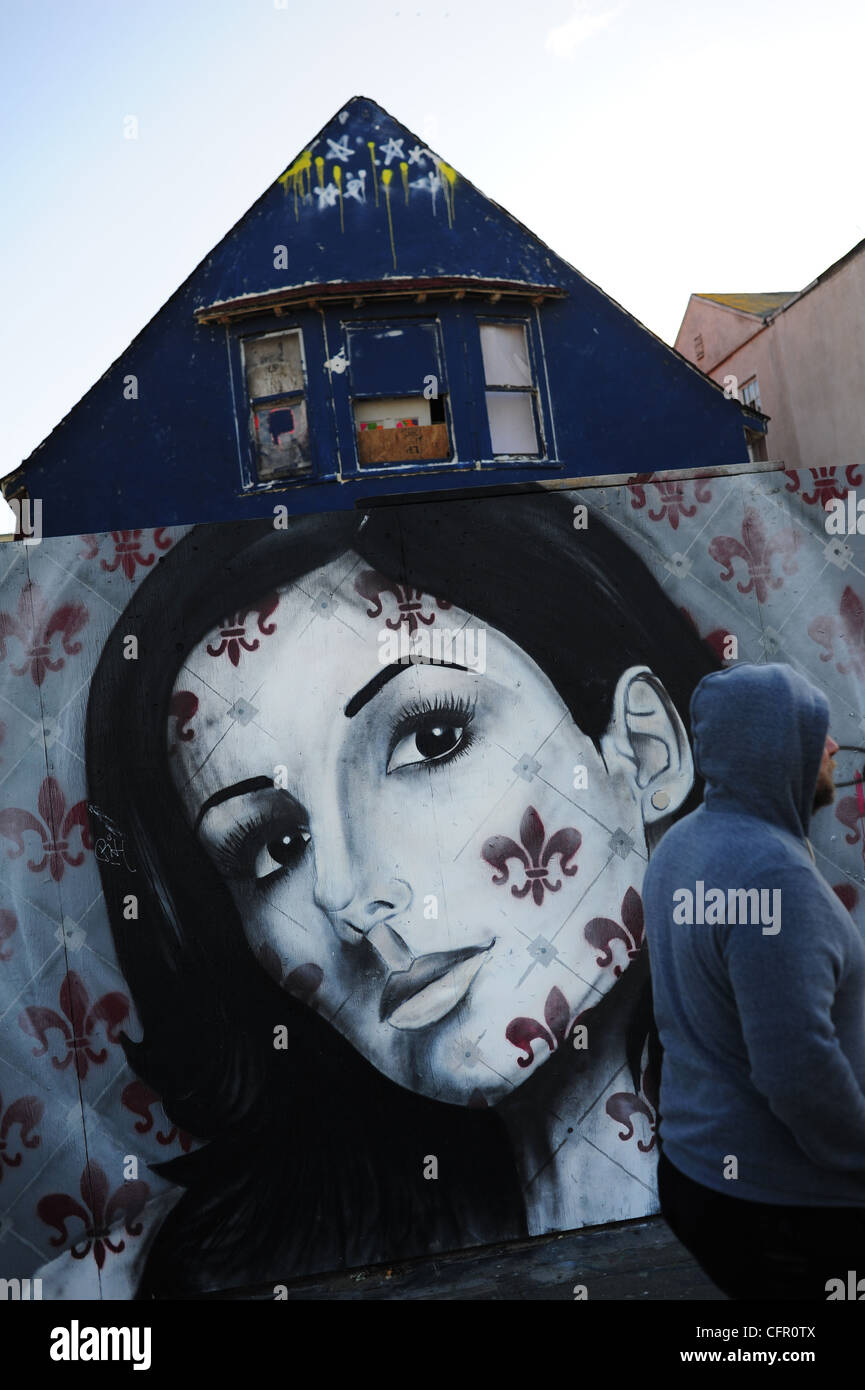 Stati Uniti d'America Sud della California a Los Angeles Venice Beach L.A. CA uomo camminare davanti a un murale di una donna di fronte a un intavolato house Foto Stock