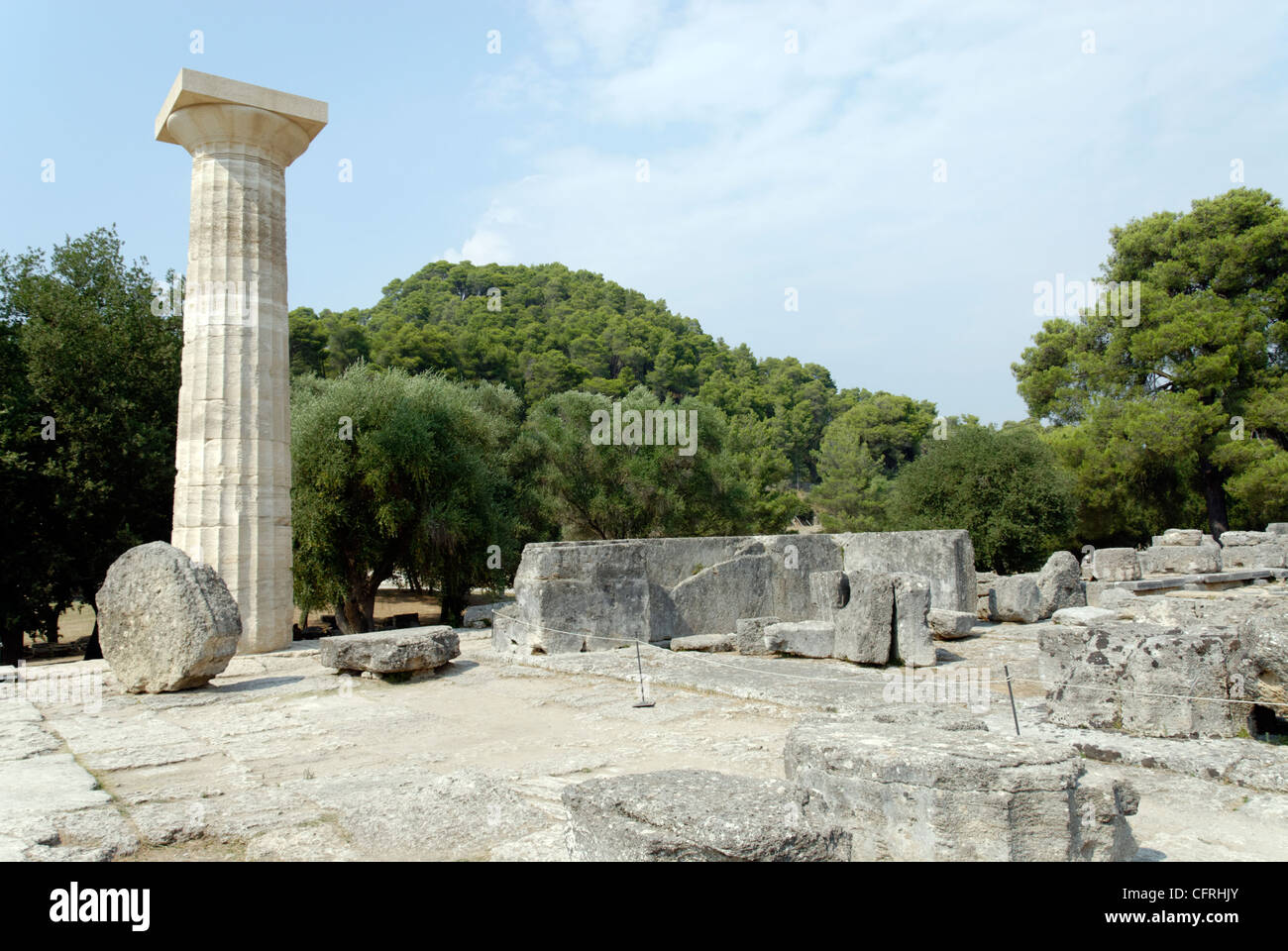 La Grecia. Vista di una ricostruzione di una colonna di solitario tra le massicce rovine della grande del V secolo il tempio di Zeus ad Olimpia. Foto Stock