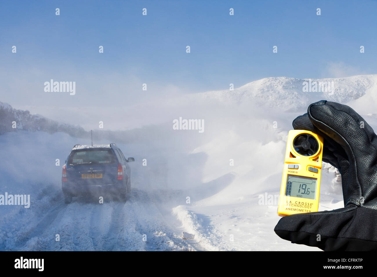 Un auto è abbandonato sul Kirkstone pass road sopra Windermere dopo che è stato bloccato dalla spindrift vento e neve soffiata. Foto Stock