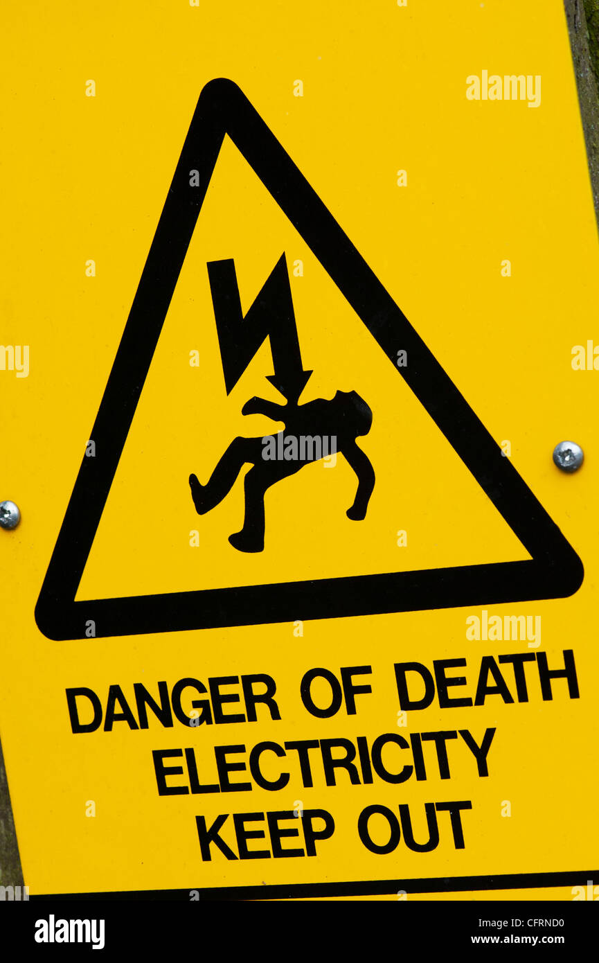 Pericolo di morte e di folgorazione. Elettricità triangolare cartello segnaletico. Regno Unito Foto Stock
