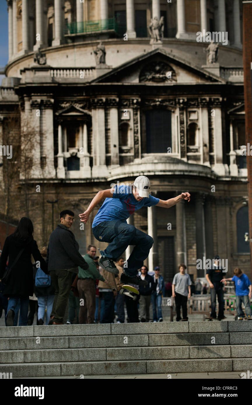 Guidatore di skateboard salta dai passi fuori la cattedrale di St Paul Foto Stock