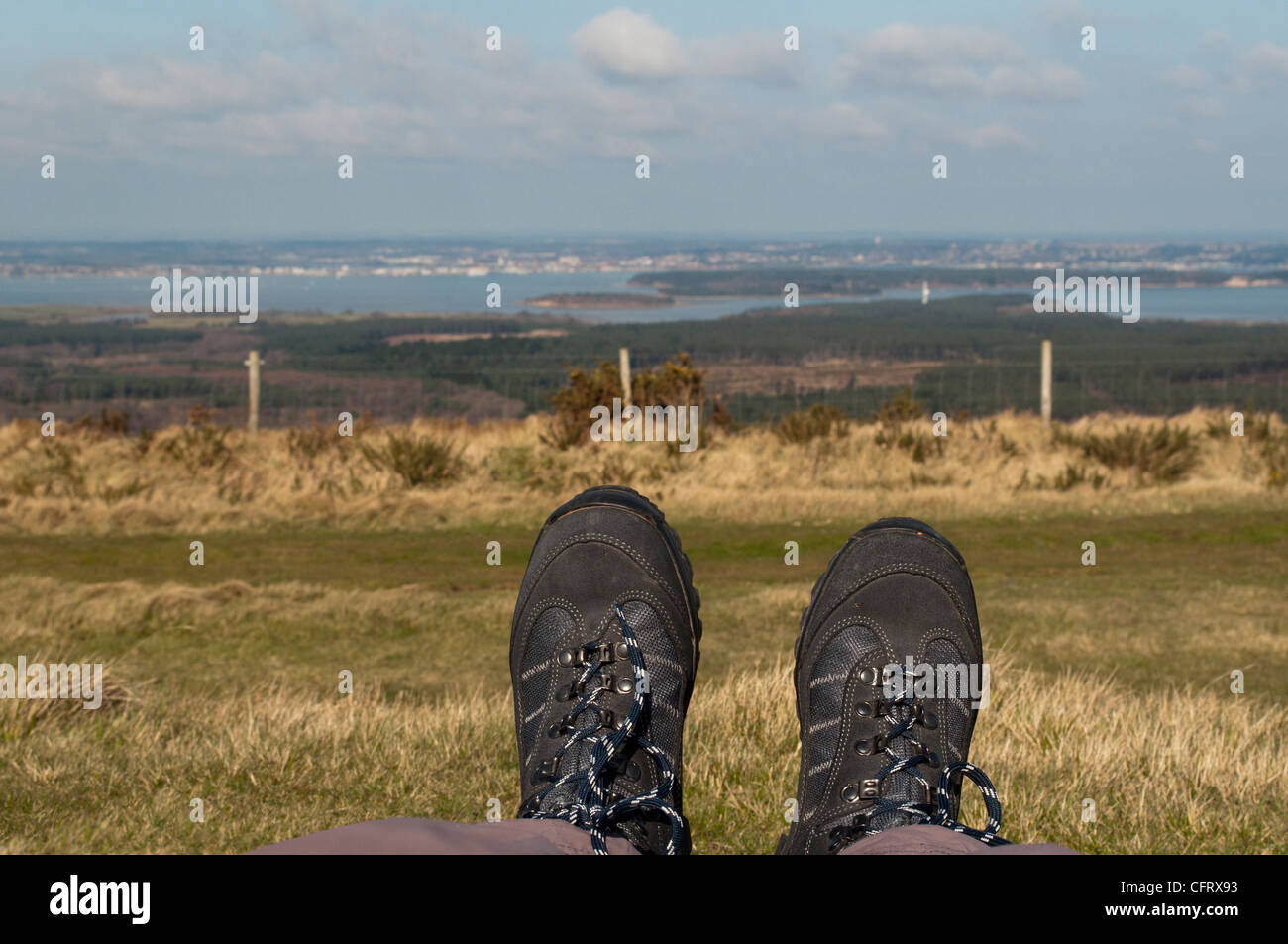 Un rilassato escursionisti vista attraverso il porto di Poole e Brownsea Island come visto da Ailwood giù sul isola di Purbeck, Dorset, Regno Unito. Foto Stock