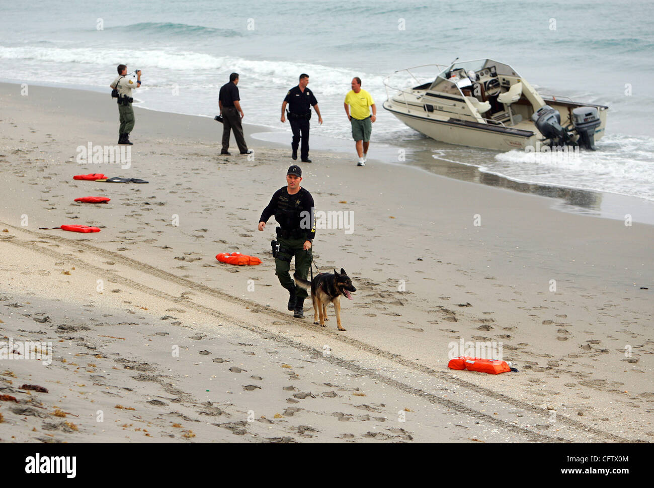 012507 ha incontrato il personale in barca foto di Richard Graulich/Palm Beach post - PALM BEACH - Palm Beach di polizia, U.S. Pattuglia di Confine e PBSO membri di guardare al di sopra di una barca abbandonata appena a nord del viale sud sulla A1A Giovedì mattina. Parecchi maschi in vestiti bagnati sono stati catturati nei pressi di Worth Avenue intorno 5:30am. Foto Stock