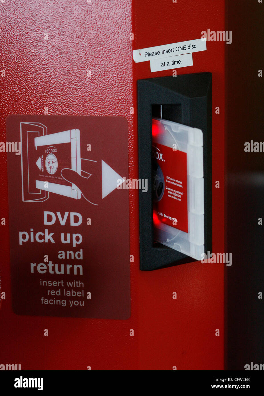 (Tampa 2/26/08)--3) un DVD viene fornito al di fuori di un riquadro rosso vending chiosco dopo Xann Leseberg (CQ), di Brandon, pagato per affittare il martedì mattina al Wal-Mart Neigbhorhood mercato. Casella rossa è un chiosco distributore automatico che si trova mediante la porta a molti esercenti che eroga circa 100 diversi DVD di $ 1 al giorno Foto Stock